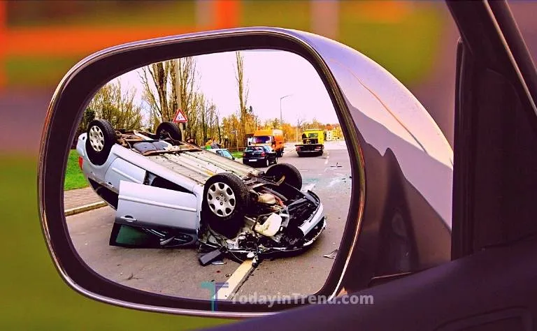 Overturned car after a crash, seen in a side mirror